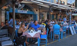 people-sit-in-sidewalk-street-cafe-in-chania-waterfront-crete