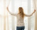 woman-looking-out-of-window-blinds